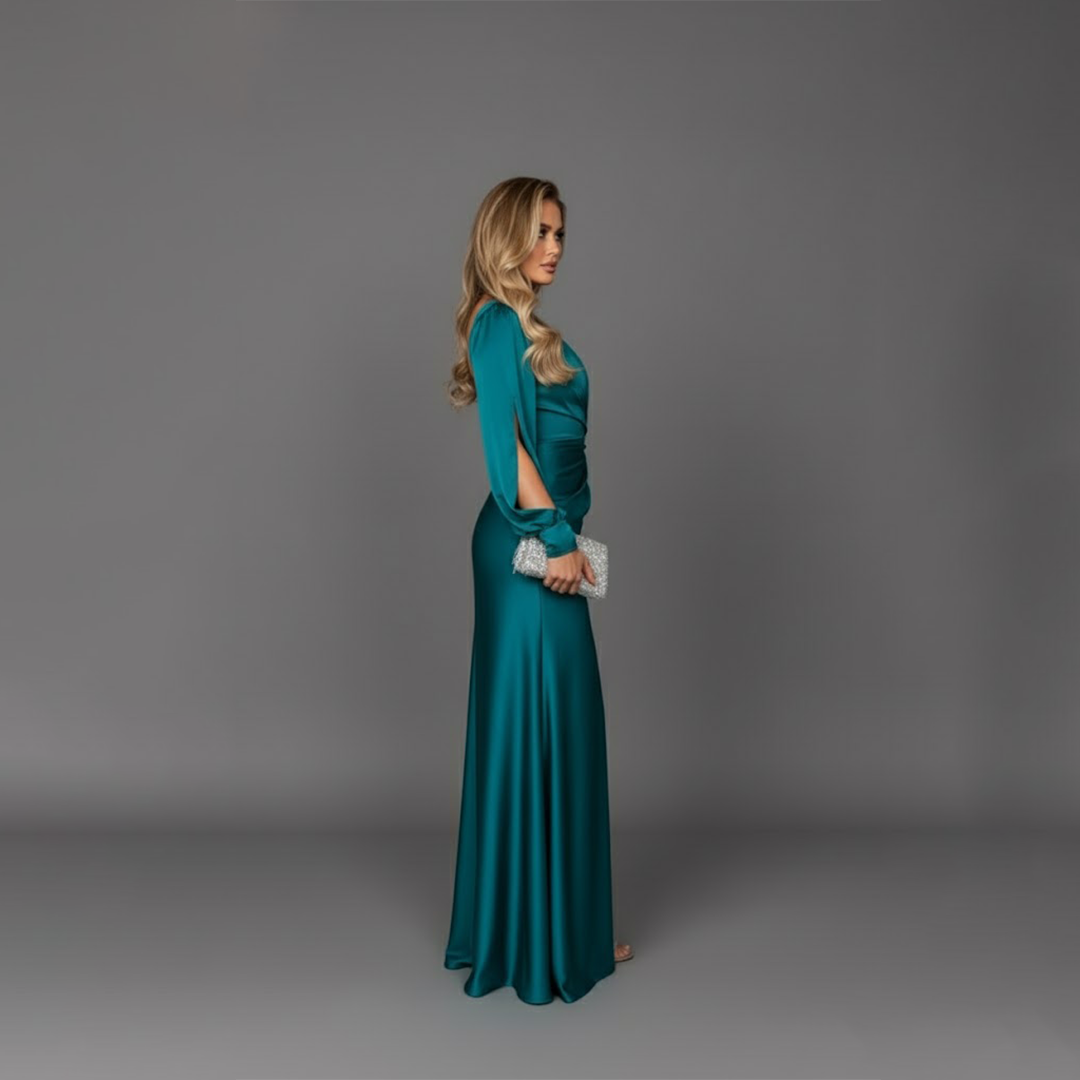 Side profile view of model in teal satin cocktail dress with single long sleeve