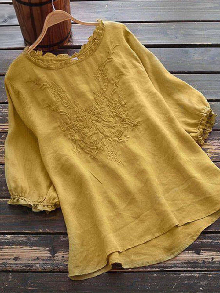 Women's yellow boho embroidered blouse with ruffle trim on hanger