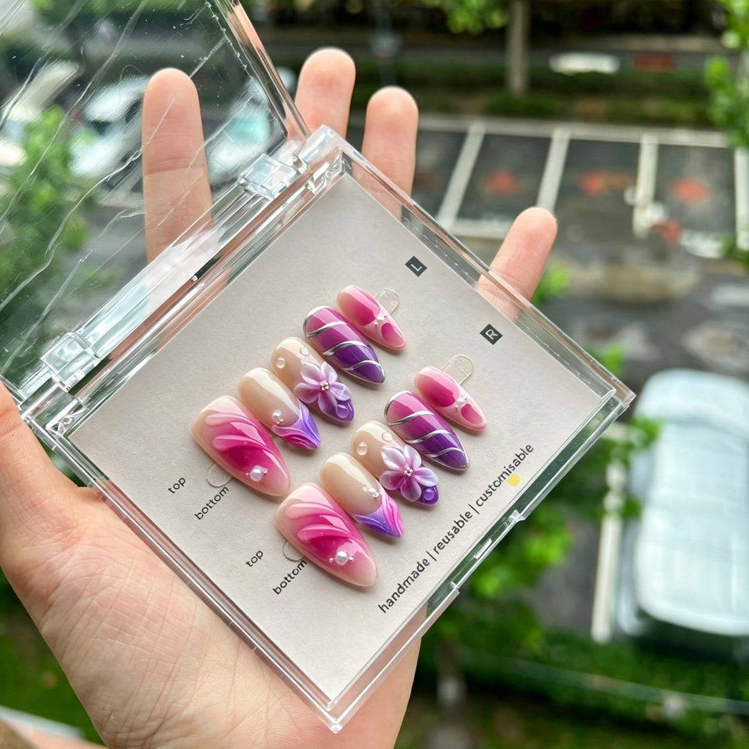 Handmade floral press-on nail art set in a storage case held in a hand