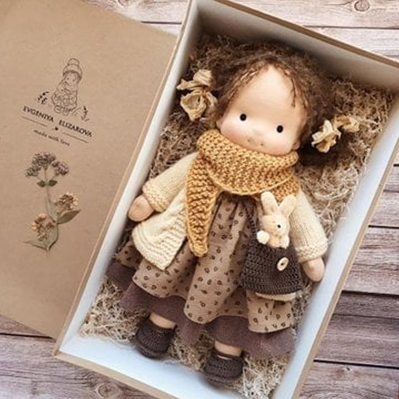 Handmade Waldorf doll in a presentation box wearing a brown dress and scarf