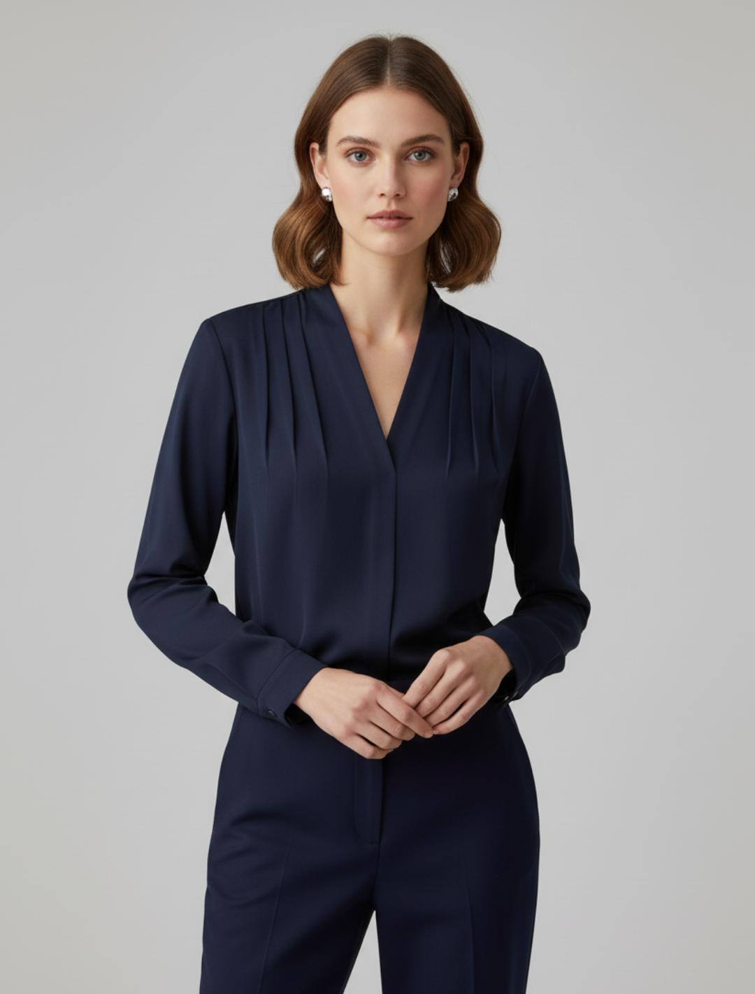 Model wearing navy blue pleated V-neck satin blouse