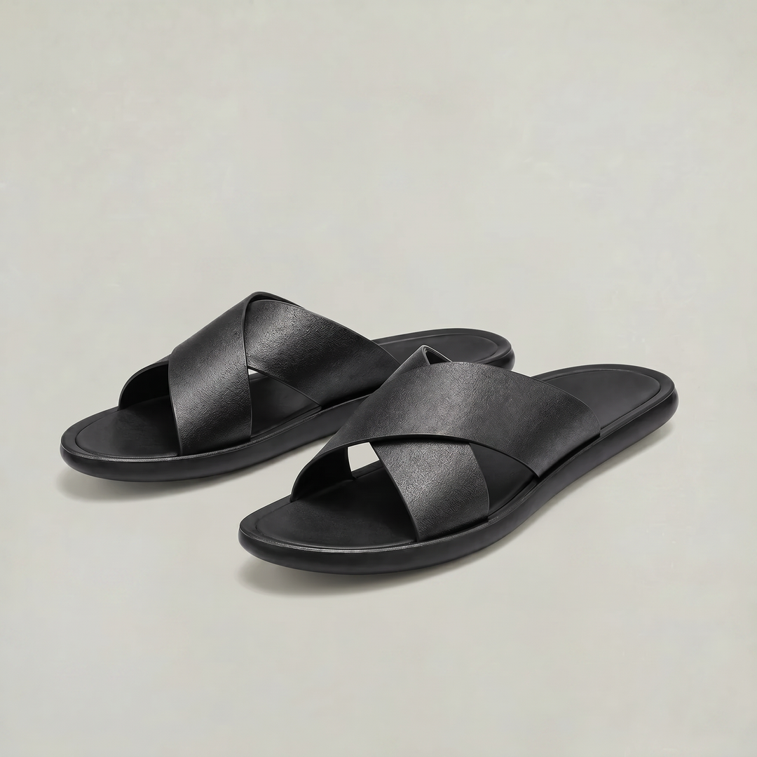 Pair of men's black slide sandals on neutral background