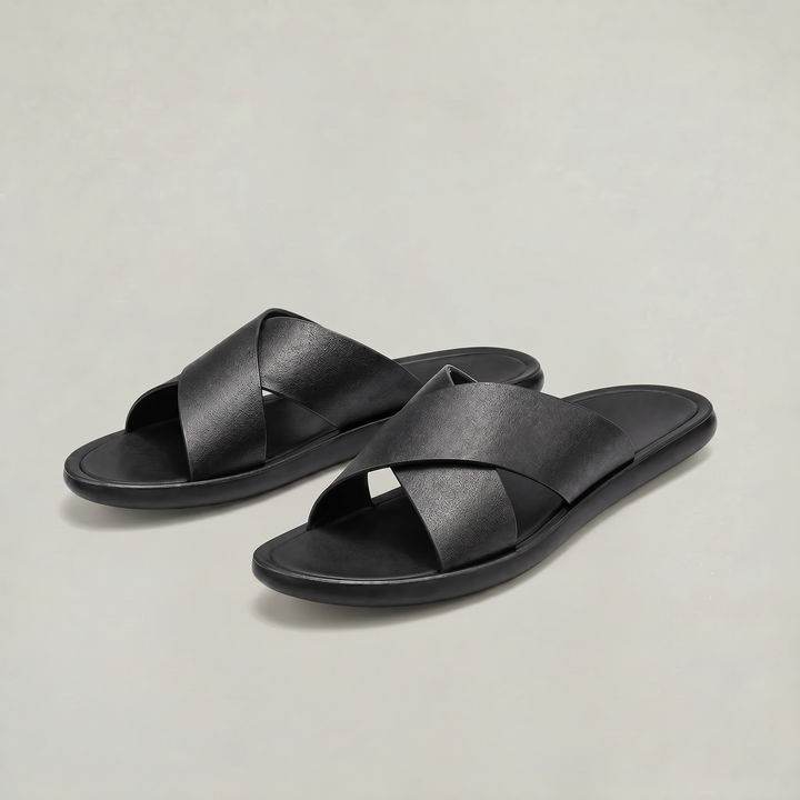 Pair of men's black slide sandals on neutral background