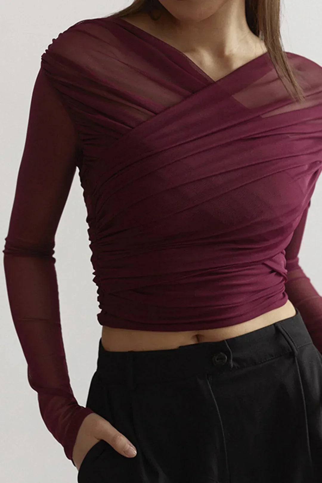 Close-up view of the draped neckline and ruched texture on the red wine top