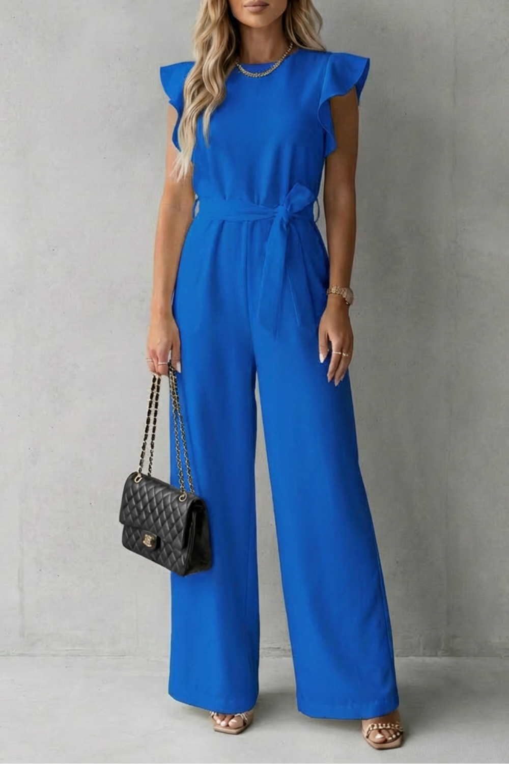 Full length shot of women's elegant ruffle sleeve belted jumpsuit for formal events