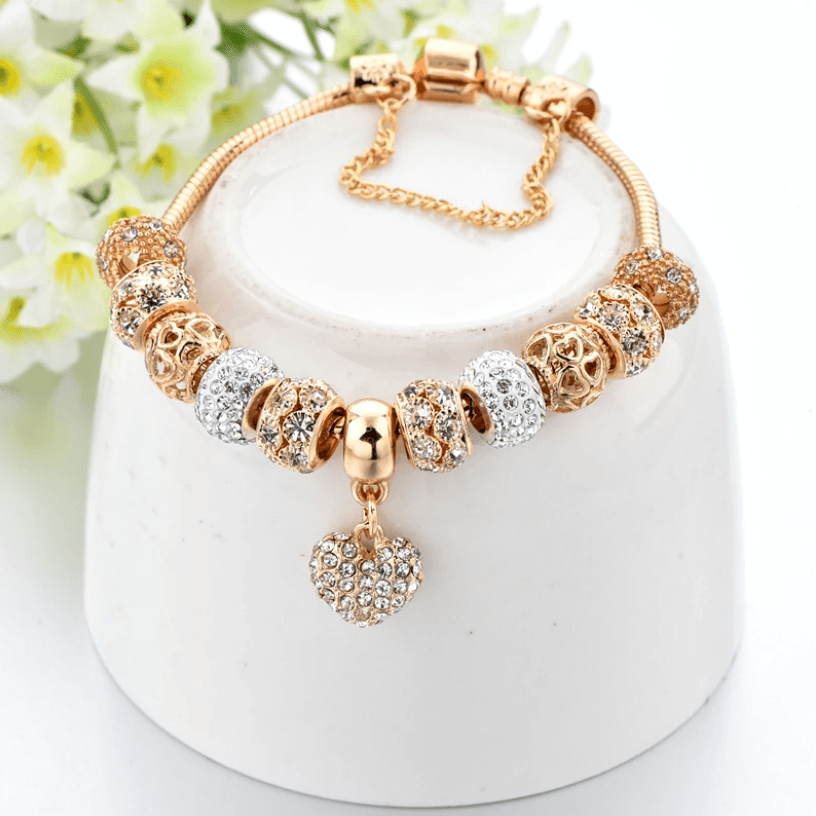 Close-up of heart charm bracelet resting on a white display stand