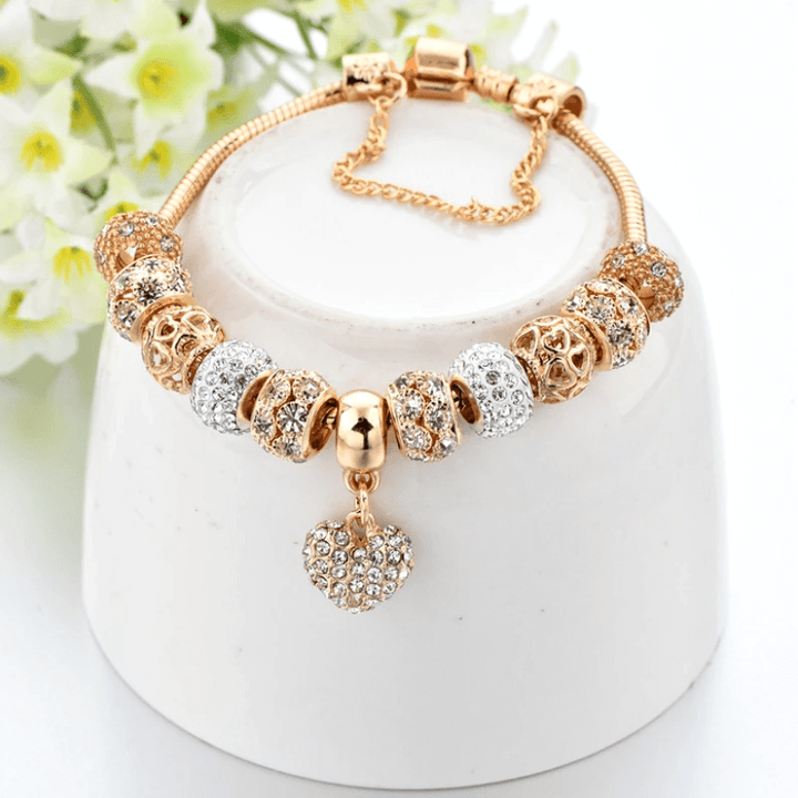 Close-up of heart charm bracelet resting on a white display stand