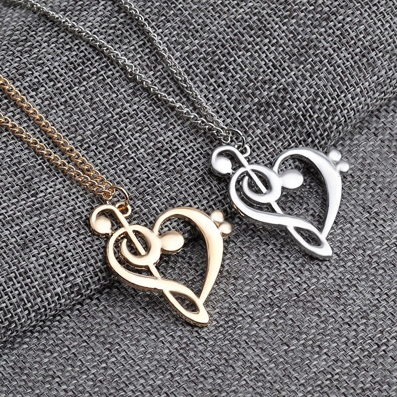 Silver and gold musical heart necklaces displayed side by side