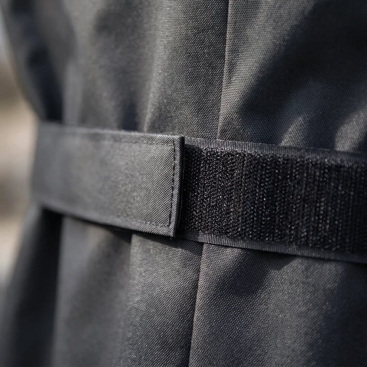 Close-up of the adjustable hook-and-loop side strap on the black grill cover