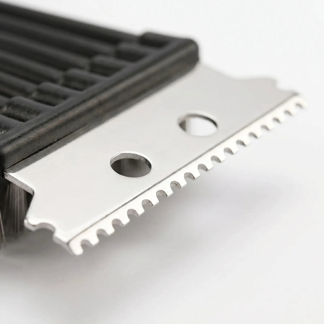 Close-up view of the stainless steel notched scraper and dense bristles on the barbecue cleaner