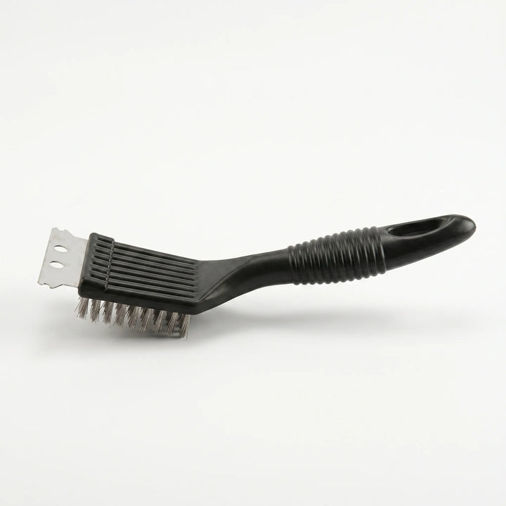 Heavy-duty grill scraper removing stubborn grease and burnt debris from outdoor barbecue grates