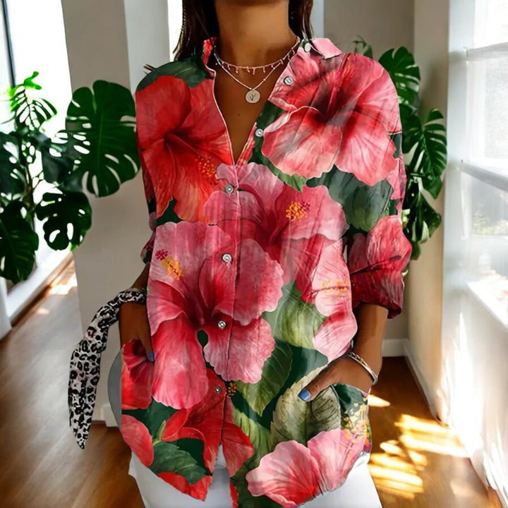 Woman wearing pink floral print long sleeve blouse with collared v-neck