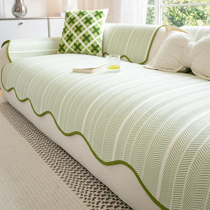 Textured herringbone sofa slipcover with decorative scallop edge showing fabric detail