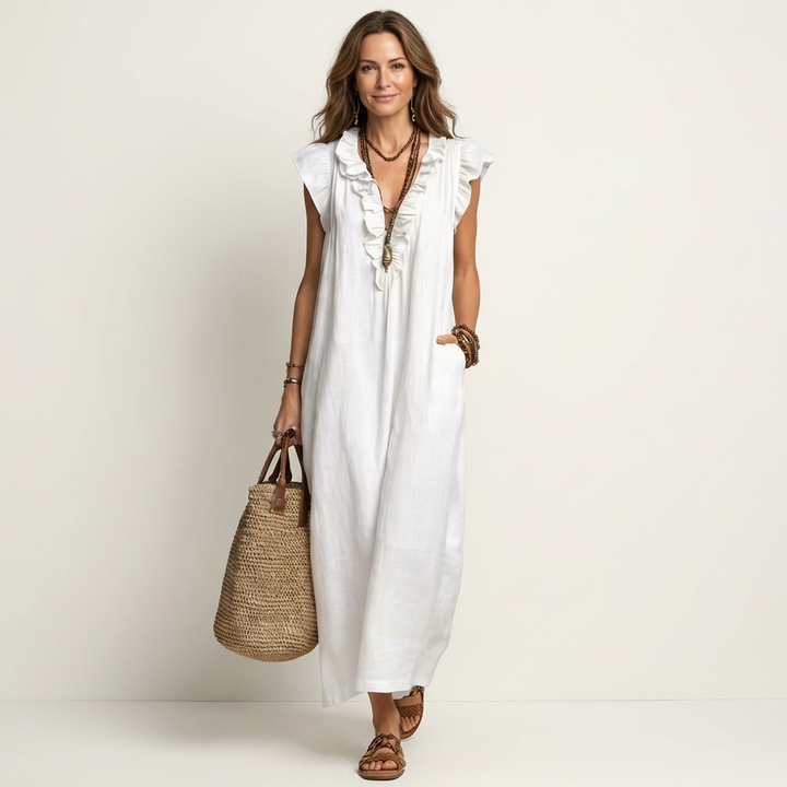 Woman wearing a white ruffle V-neck maxi dress with layered necklaces