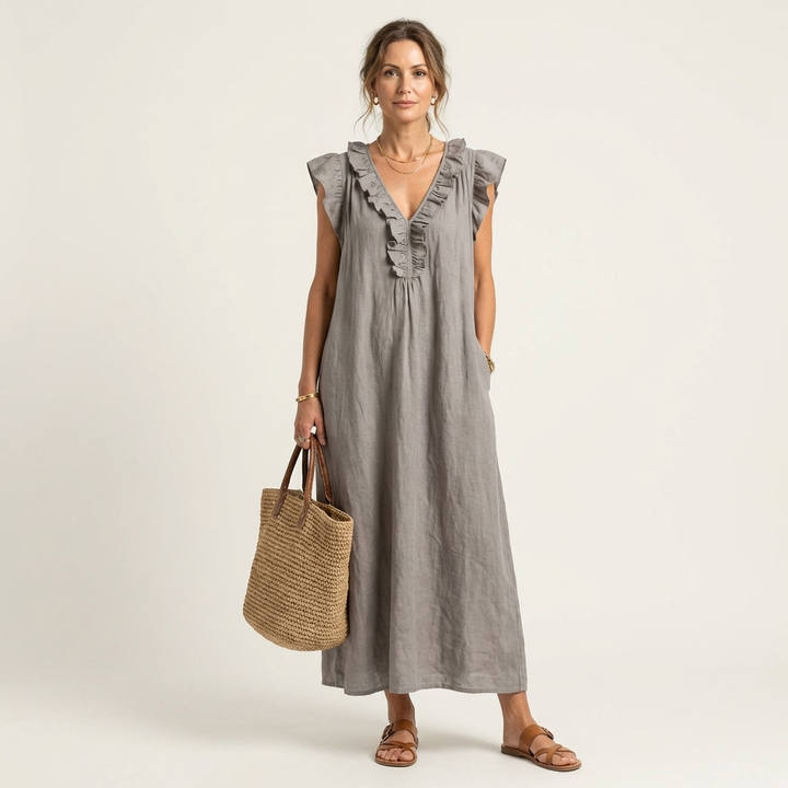 Woman wearing a grey ruffle V-neck maxi dress with a woven handbag and sandals