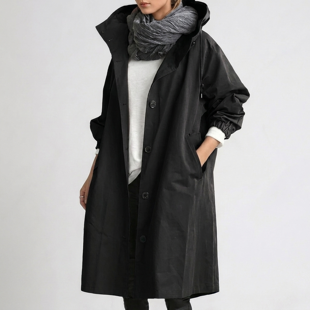 Woman wearing black hooded waterproof raincoat with pockets