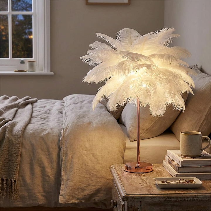 Feather table lamp glowing warmly on a rustic bedside table next to books and a mug
