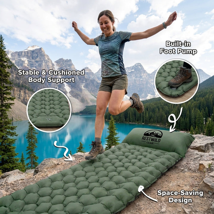 Woman jumping next to an inflated outdoor sleeping pad near a scenic lake