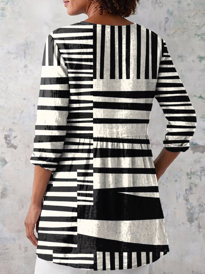 Back view of a woman wearing a geometric patterned long V-neck blouse