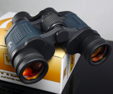 High-power waterproof binoculars resting on a retail box showcasing multi-coated lenses