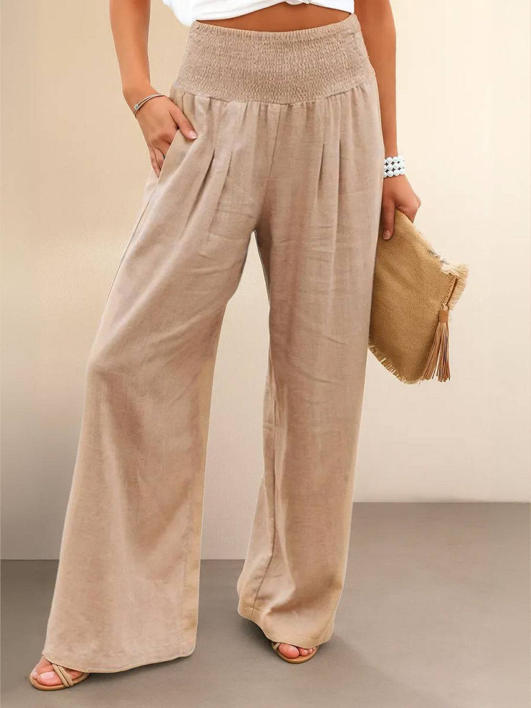 Woman wearing khaki high waist smocked wide leg palazzo trousers