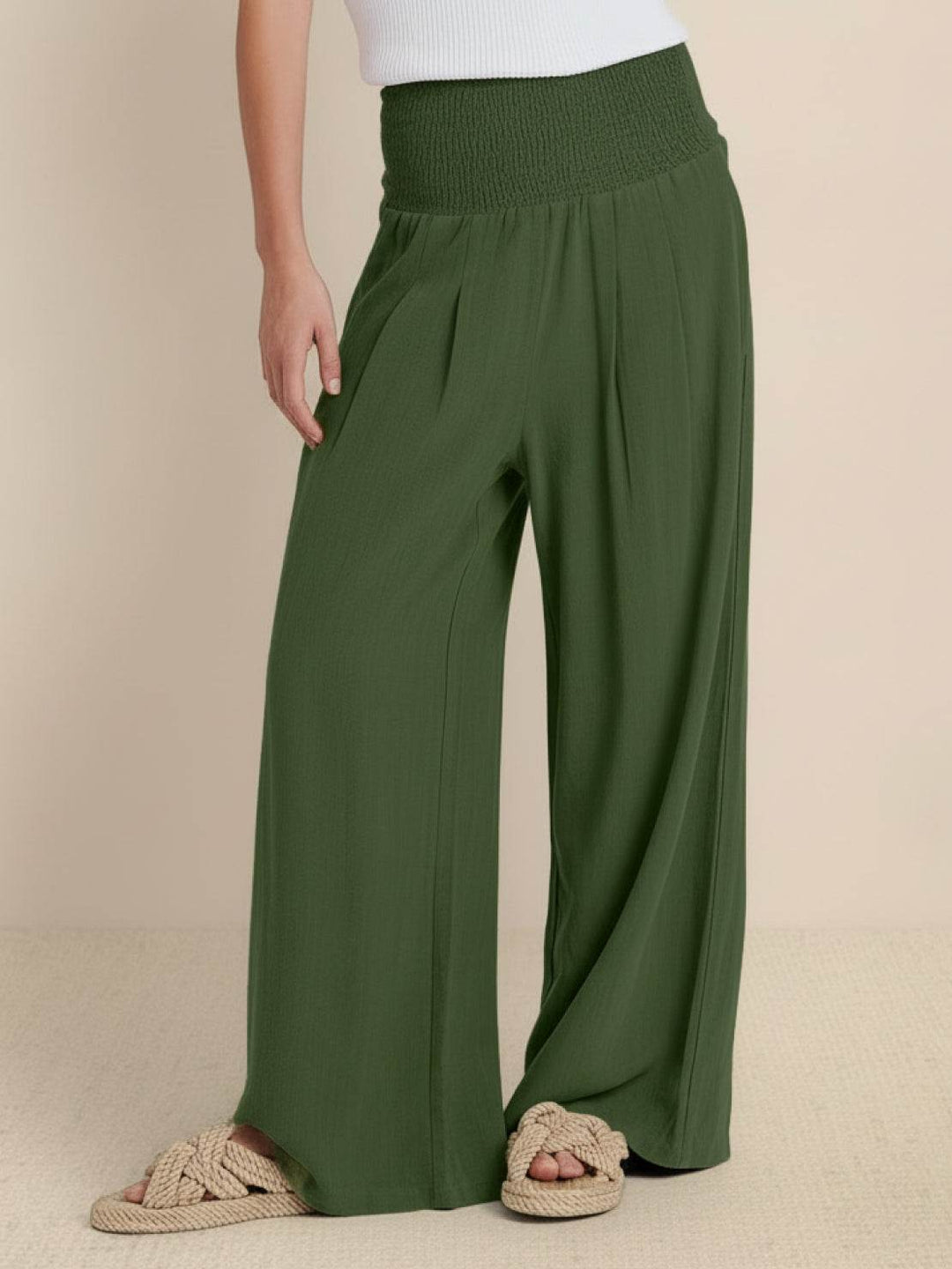Woman wearing army green high waist smocked wide leg palazzo trousers