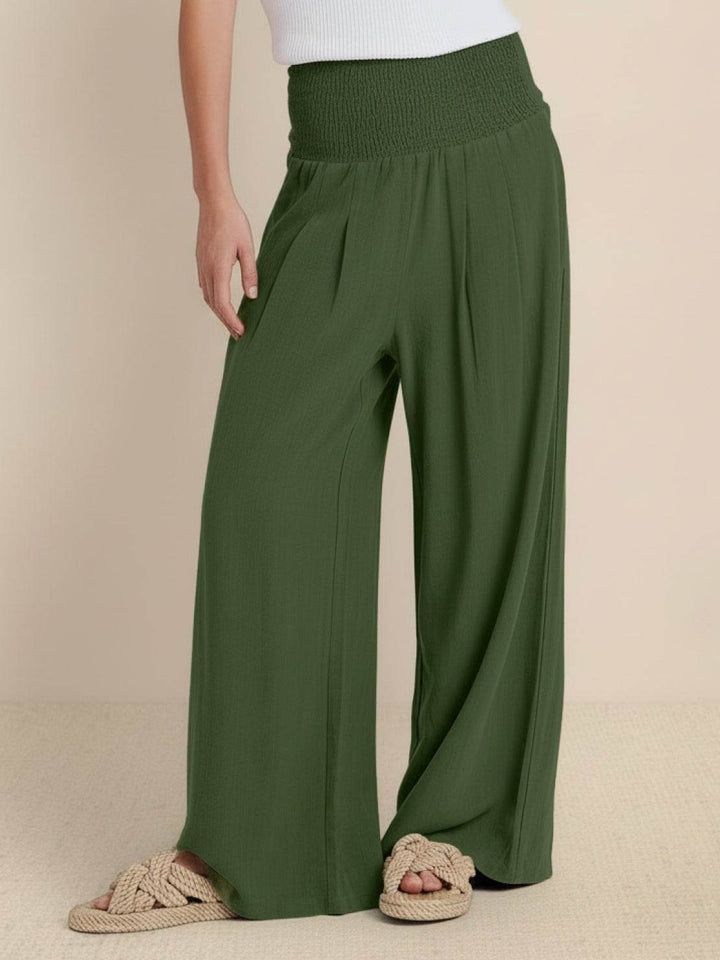Woman wearing army green high waist smocked wide leg palazzo trousers