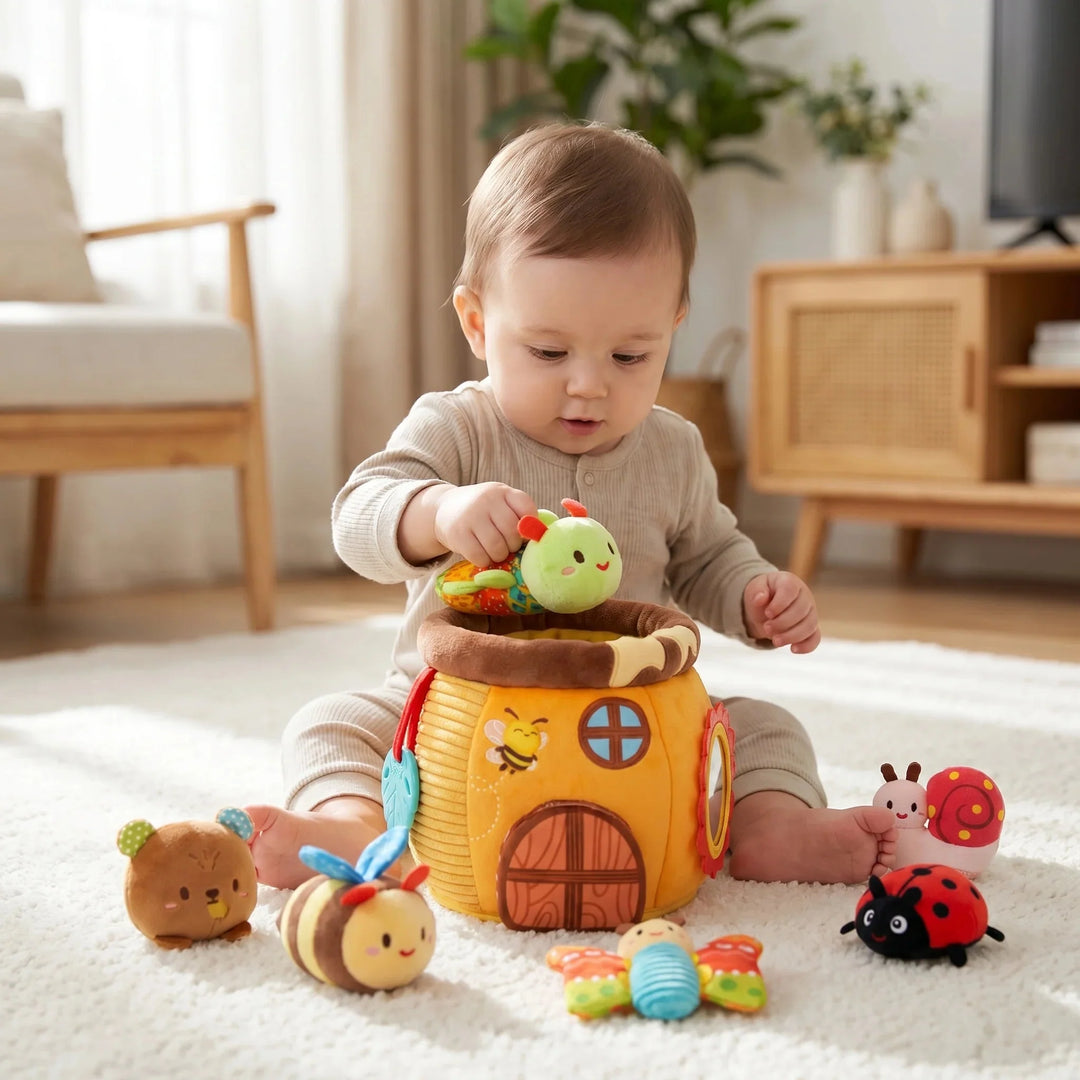 Toddler pulling a plush caterpillar toy out of a honey pot activity set