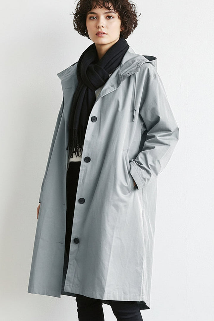 Model wearing a light grey hooded waterproof trench coat with black scarf