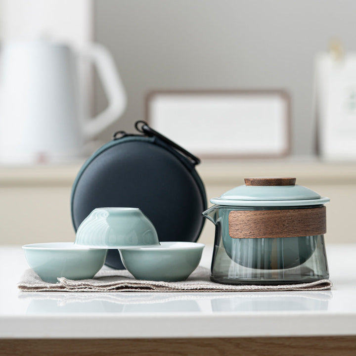 Travel tea set components laid out showing the teapot, infuser strainer, and matching cups