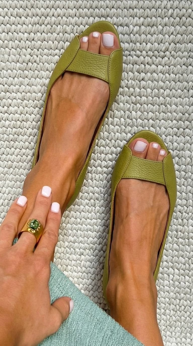 Pair of stylish metallic flat sandals displayed against a neutral background