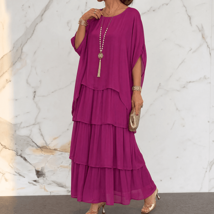 Angled view of flowing batwing sleeve chiffon dress
