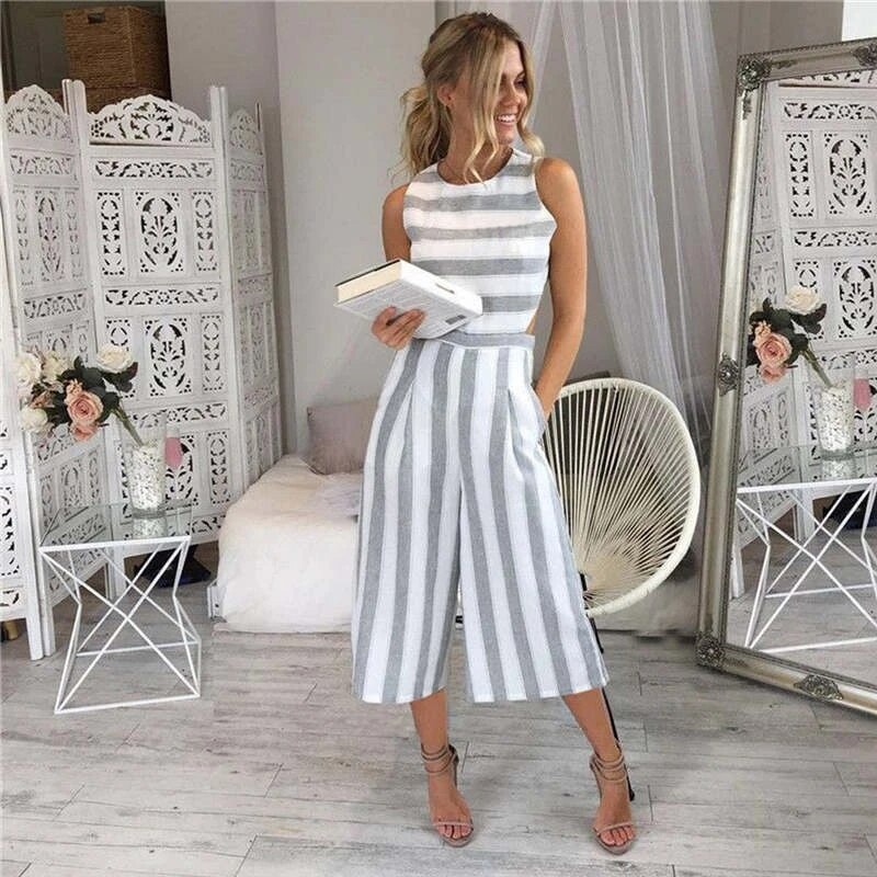 Woman wearing grey striped sleeveless wide-leg jumpsuit with cut-outs