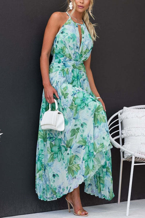 Woman wearing green floral halter maxi dress with white handbag outdoors
