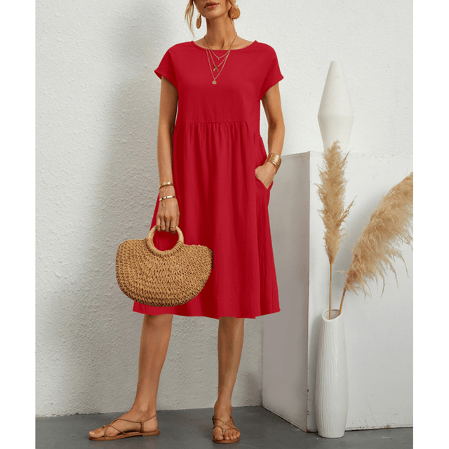 Woman wearing a vibrant red short sleeve midi dress with side pockets and sandals