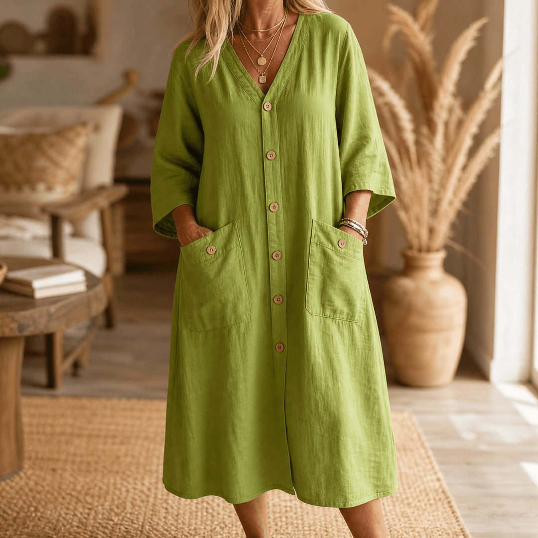 Woman wearing an olive green button-front midi dress with patch pockets