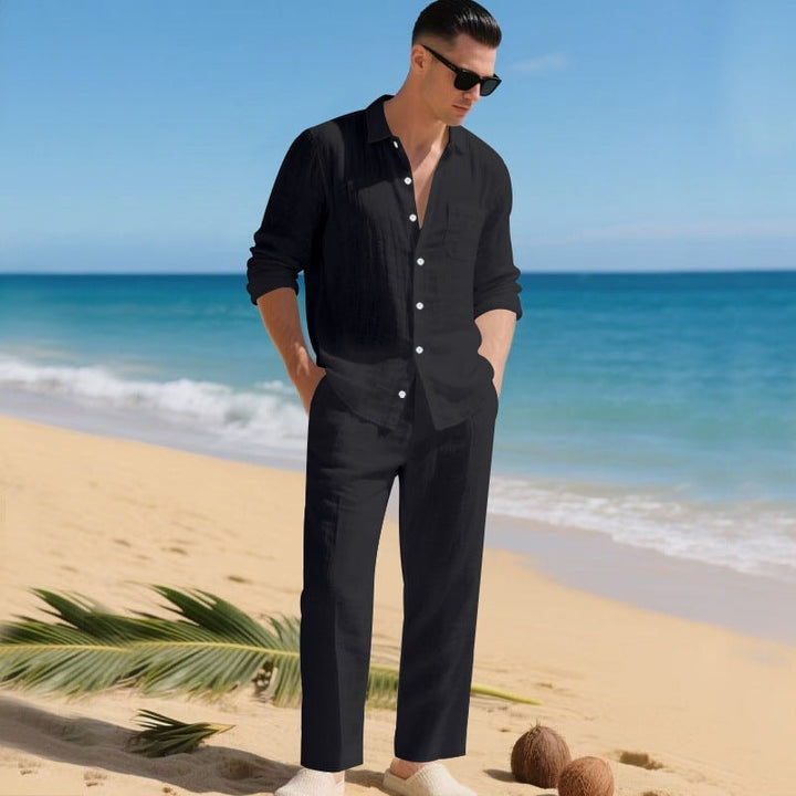 Man wearing a black matching long-sleeve shirt and trousers set on a beach