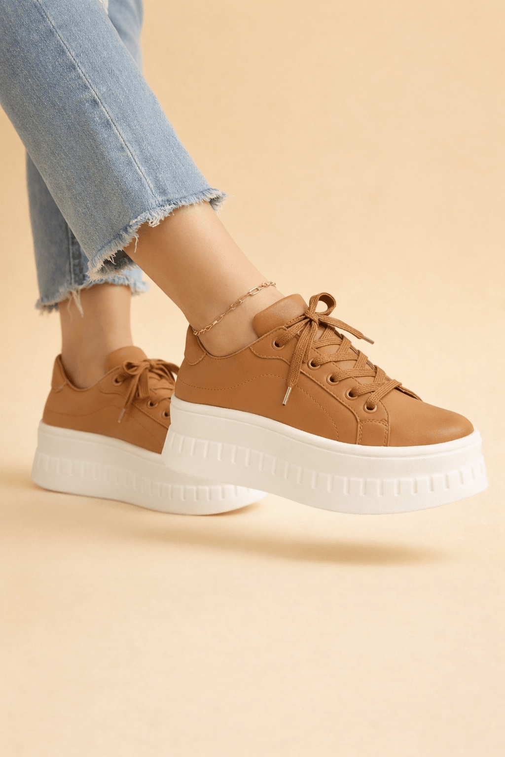 Brown platform sneakers worn with distressed denim jeans