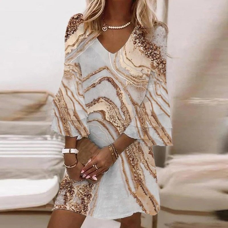 Woman wearing a khaki and white marble swirl print mini dress with V-neck and flared sleeves