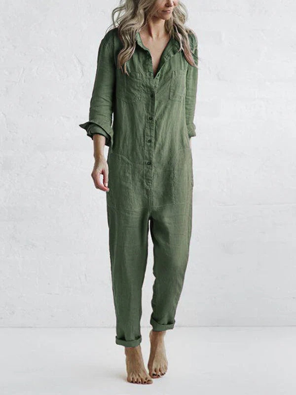Woman wearing a green button-front utility jumpsuit with roll-up cuffs