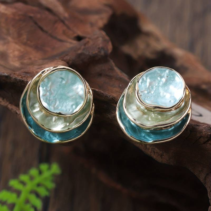 Close-up of women's vintage hand-painted multi-layered round stud earrings with enamel finish.