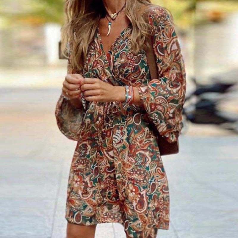 Close-up view of the V-neckline and tie-front waist details on the brown paisley mini dress.