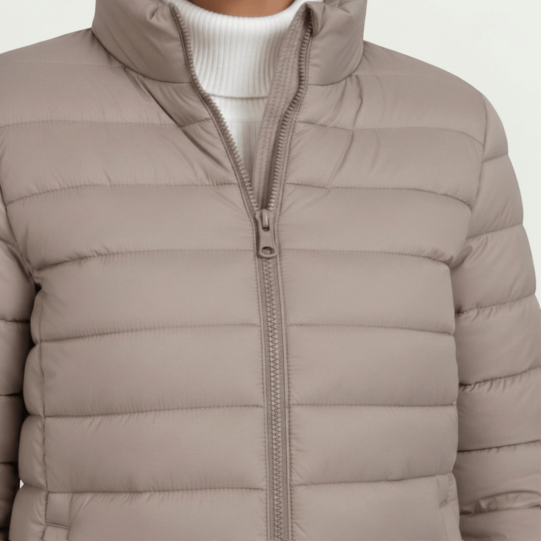 Close-up of the beige quilted jacket front zipper and high collar