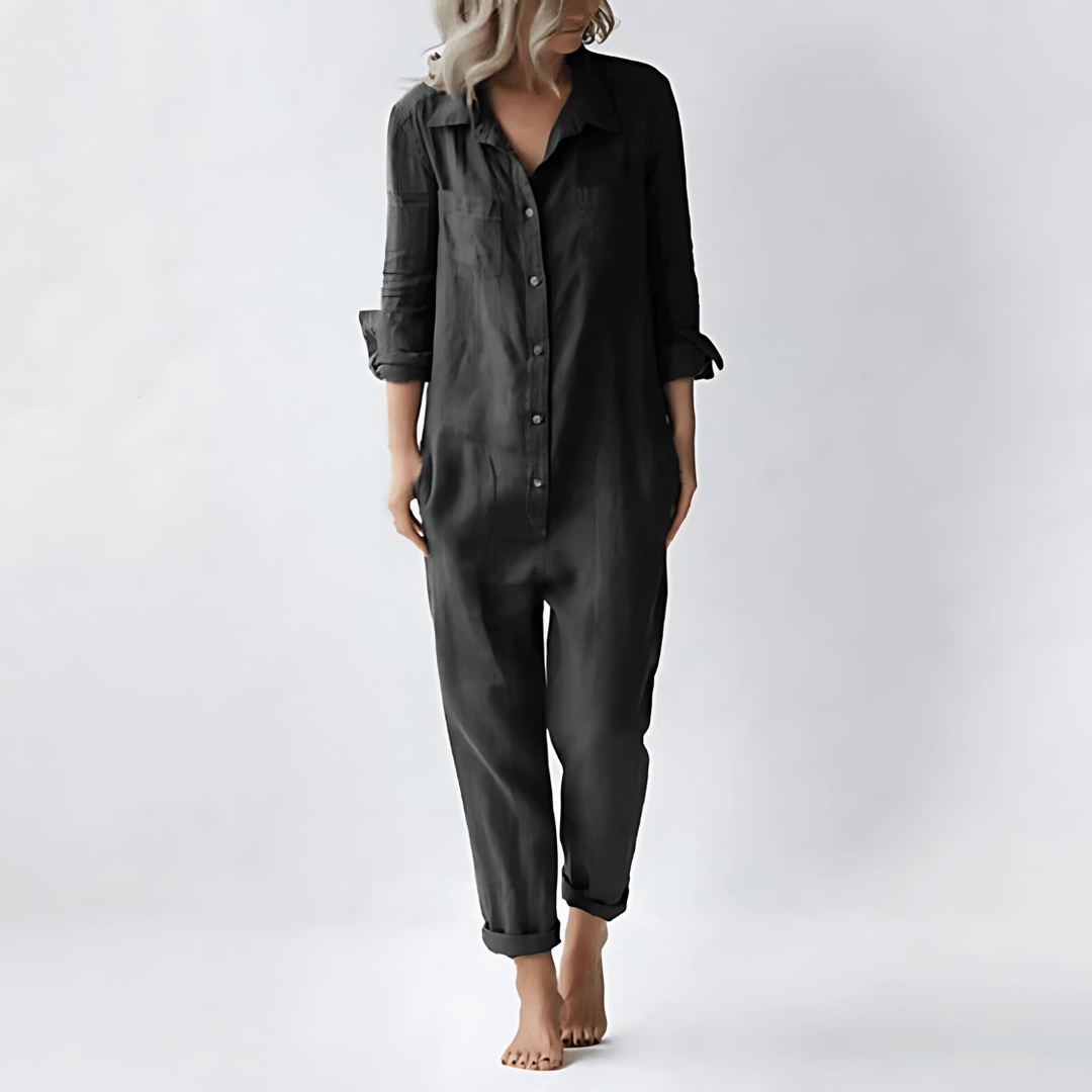 Woman wearing a black collared button-front jumpsuit with side pockets