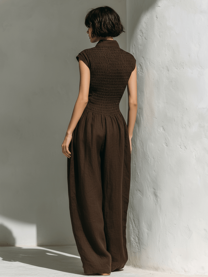 Back view of a model in a coffee brown V-neck jumpsuit showing tailored waist detailing.