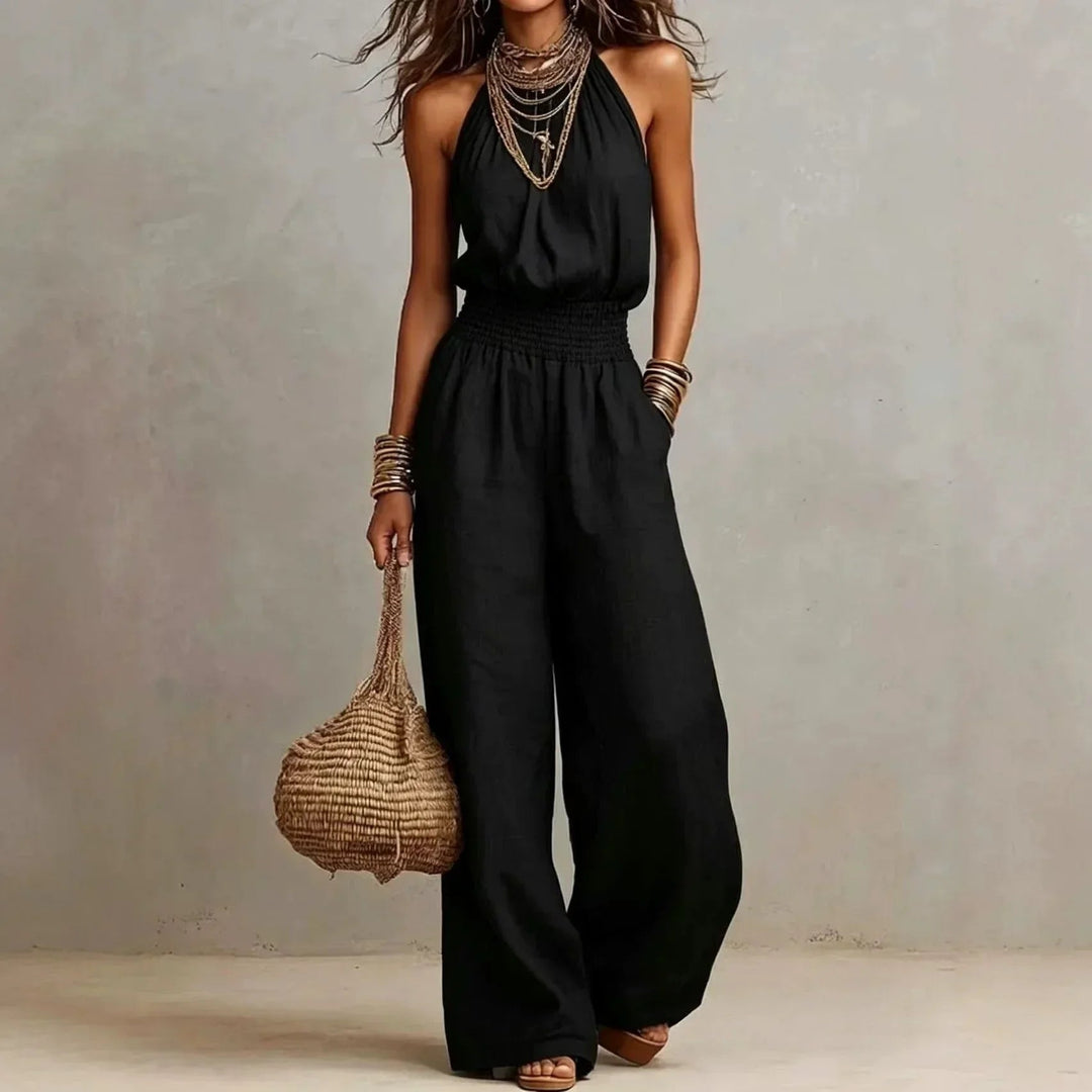 Woman wearing a black halter neck wide leg jumpsuit with pockets