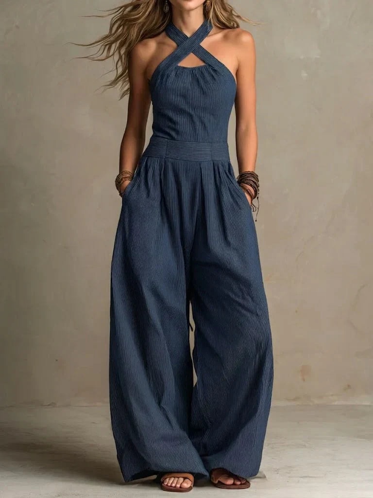 Woman wearing a navy blue cross-neck halter wide-leg jumpsuit outdoors