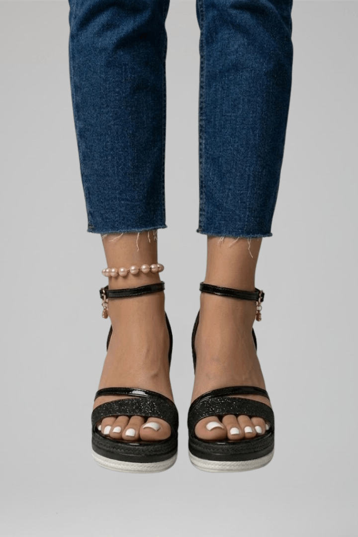 Close-up of model wearing black wedge platform sandals