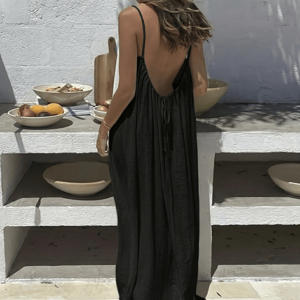 Back view of a woman wearing a black backless maxi dress with adjustable straps