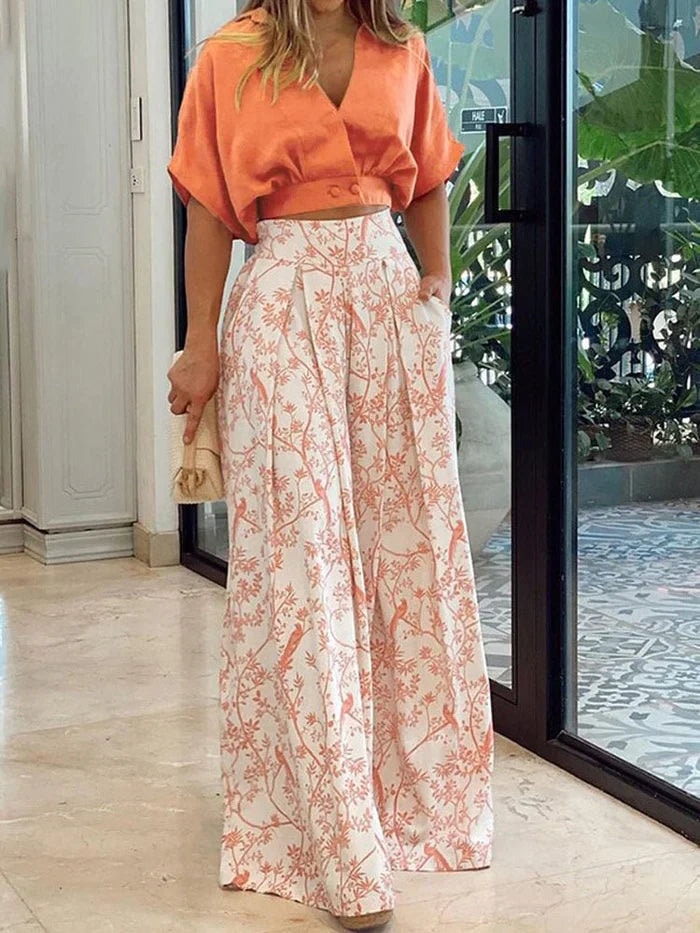 Woman wearing an orange and white floral wide-leg two-piece co-ord set